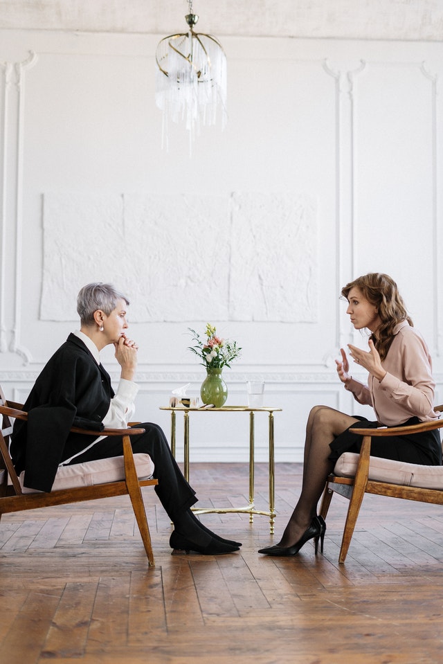 Female coatch chatting with a patient in a country salon sitting face to face.