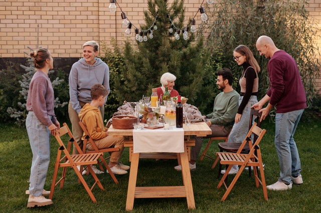 Photo of a family sharing an outdoor meal in a garden courtyard.
