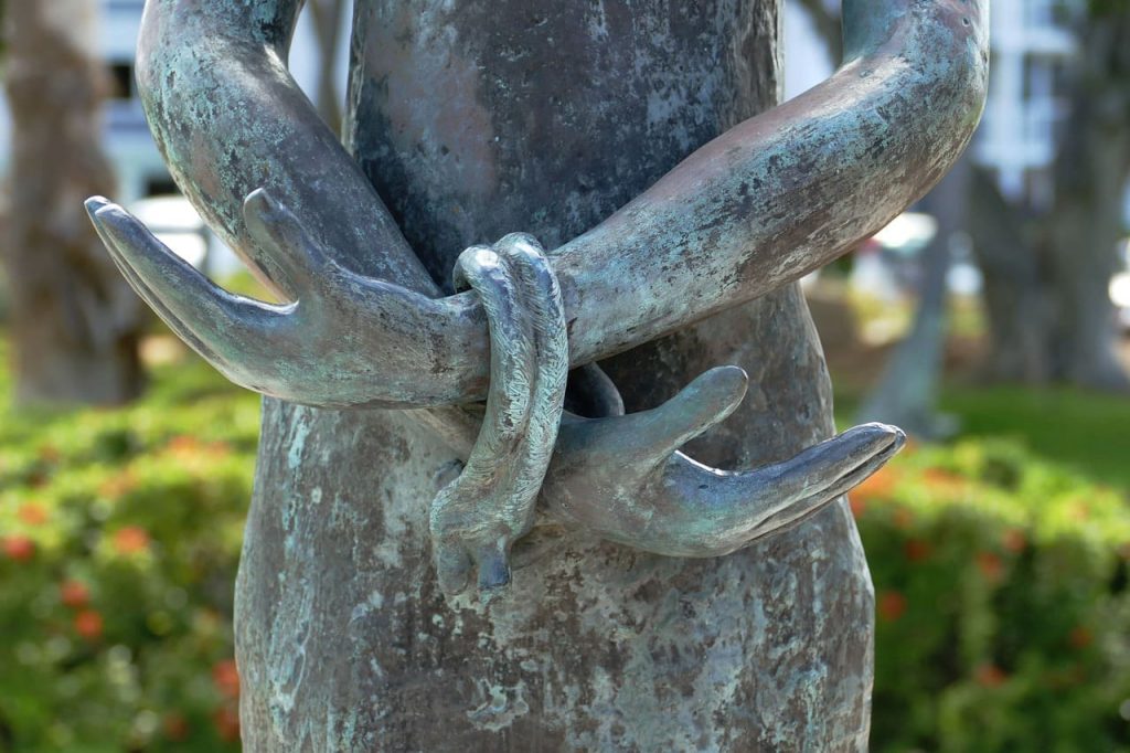 Close-up of an iron sculpture showing two tied hands.