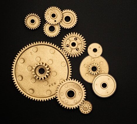 Photo of gold gears on solid black background