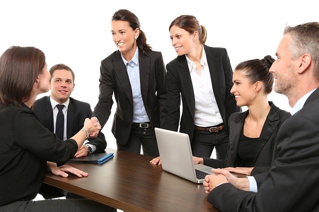 Male and female business people in a meeting leading to an agreement and a handshake